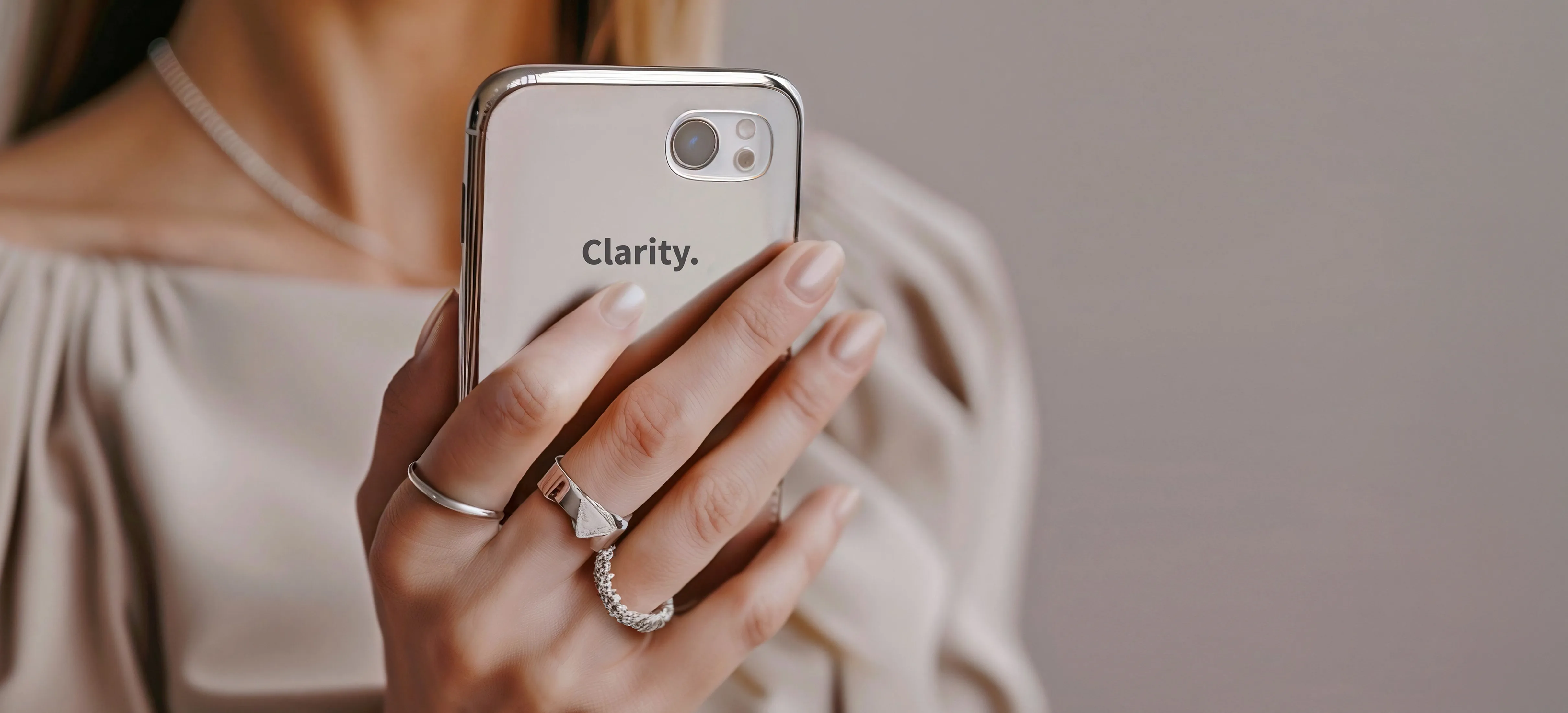 Frau. hält Smartphone, auf dessen Hülle Clarity steht