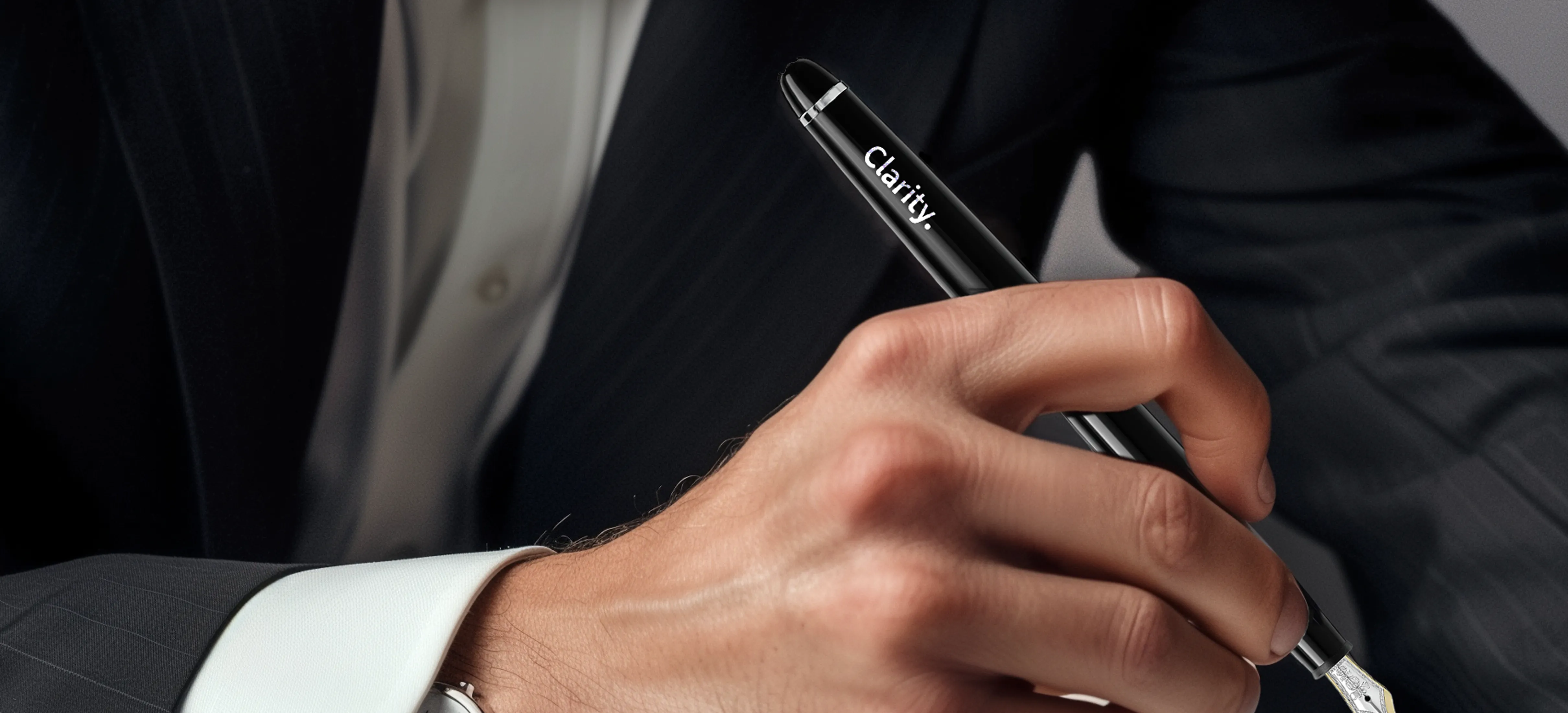 Person in einem Anzug, die einen Füllfederhalter in der Hand hält, auf dem die Aufschrift Clarity steht